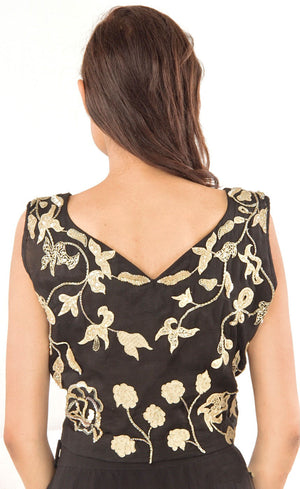 This black two-piece set is perfect for you to add into your collection. It comprises of a simple top with round neckline at the front and enhanced v-neckline at the back. It is intricately hand-embroidered with golden work silk threads, beads and sequins. This is further paired with a panelled skirt with perfect amount of flounce giving you a look that's both smart and eye-catching.