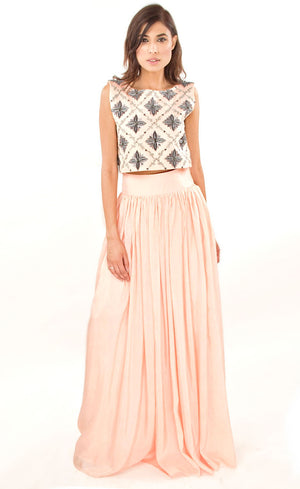 The muse here is wearing our blush pink cropped top with skirt set. The dress comprises of a crop-top which has strong motifs embroidered with silk threads, beads, sequins and silver grey work, paired with a highly flared skirt providing you the perfect amount of flow which is further attached to a thick waistband. This skirt set is perfect as it highlights the waistline and makes the person wearing it look taller and perfects the height ratio.
