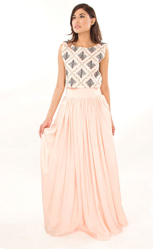 The muse here is wearing our blush pink cropped top with skirt set. The dress comprises of a crop-top which has strong motifs embroidered with silk threads, beads, sequins and silver grey work, paired with a highly flared skirt providing you the perfect amount of flow which is further attached to a thick waistband. This skirt set is perfect as it highlights the waistline and makes the person wearing it look taller and perfects the height ratio.