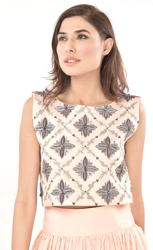 The muse here is wearing our blush pink cropped top with skirt set. The dress comprises of a crop-top which has strong motifs embroidered with silk threads, beads, sequins and silver grey work, paired with a highly flared skirt providing you the perfect amount of flow which is further attached to a thick waistband. This skirt set is perfect as it highlights the waistline and makes the person wearing it look taller and perfects the height ratio.