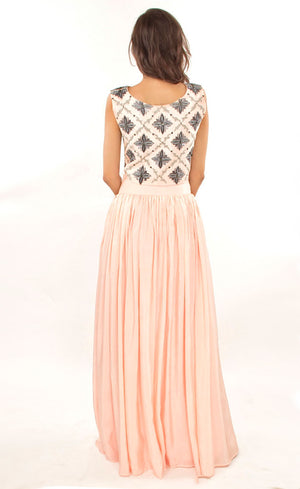 The muse here is wearing our blush pink cropped top with skirt set. The dress comprises of a crop-top which has strong motifs embroidered with silk threads, beads, sequins and silver grey work, paired with a highly flared skirt providing you the perfect amount of flow which is further attached to a thick waistband. This skirt set is perfect as it highlights the waistline and makes the person wearing it look taller and perfects the height ratio.