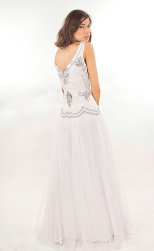 The muse here is wearing our cloud white tulle net gown with it's upper body intricately hand-embroidered with silk threads, beads, sequins in a silver grey palette. The gown gives you the look and confidence you deserve and thus is ideal for a beach wedding or any other evening event.