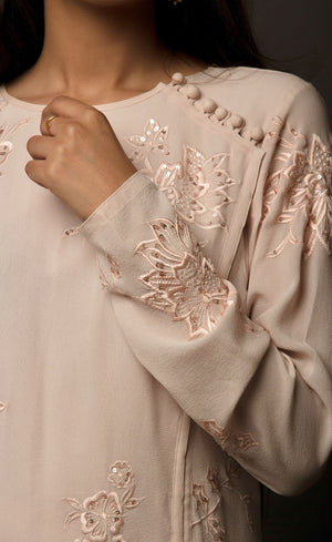 Dusty Rose side slit suit set, crafted in georgette, fully embroidered with signature flat threadwork topped with sequins spray accompanied by a dupatta with rose gold mukaish border. The ensemble carries a strong of a confident style because of the slim straight trousers underneath, the bottom of the trousers is finished by our signature buttoned hemline style. Flaunt your chic style in this elaborately worked ensemble, the muse radiates a modern, yet classic vibe.
