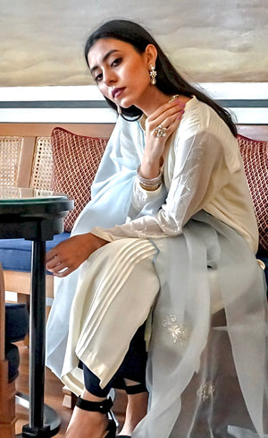 The Kurta is paired with a deep-blue wide-legged crepe palazzos accompanied by a powder blue silk organza dupatta which is beautifully sheer and is embellished with motifs made of beads and sequins handwork, hemline finished by a scalloped thread-work.
