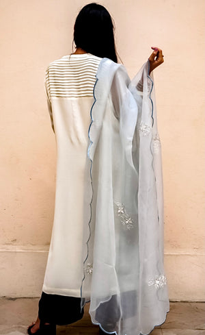 The Kurta is paired with a deep-blue wide-legged crepe palazzos accompanied by a powder blue silk organza dupatta which is beautifully sheer and is embellished with motifs made of beads and sequins handwork, hemline finished by a scalloped thread-work.