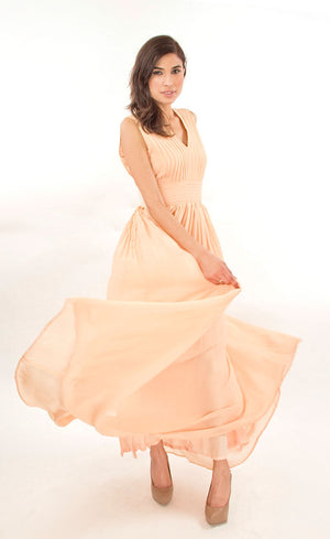 This nude elegant flowy floor-length gown has simple v-neckline bringing out a certain amount of boldness and self assurance. It is pin-tucked at the yoke and waistline making it an ideal go-to gown for any evening cocktail event.