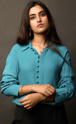 This peacock blue-green classic loop-buttoned business shirt crafted in cupro georgette, with gathered full sleeves, focuses on the modern muse and exudes a sophisticated touch of classic. With its beautiful drop shoulders, it adds a sense of creativity to your shirt style.
