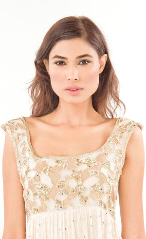 This is a simple and effortlessly elegant pearl silk beaded gown with a beautiful empire waist line partially embroidered with beads, sequins and gold work across the yoke area in the front as well as the rear. This flowy gown allows you to feel all the freedom around and is finished with gota appliqué work along the bottom flare.