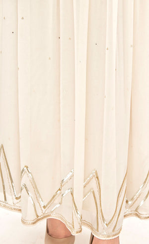 This is a simple and effortlessly elegant pearl silk beaded gown with a beautiful empire waist line partially embroidered with beads, sequins and gold work across the yoke area in the front as well as the rear. This flowy gown allows you to feel all the freedom around and is finished with gota appliqué work along the bottom flare.
