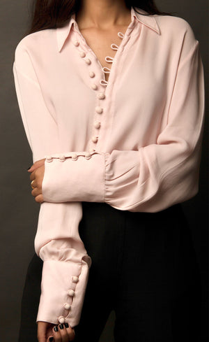This powder pink classic loop-buttoned business shirt crafted in cupro georgette, with gathered full sleeves, focuses on the modern muse and exudes a sophisticated touch of classic. With its beautiful drop shoulders, it adds a sense of creativity to your shirt style.