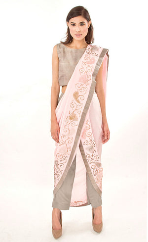 The muse here is wearing our rose pink ready to wear dhoti sari drape with trousers. It is a playful look to spice up your traditional game into something really trendy. This comprises of a silk chiffon dhoti sari drape intricately embroidered with hand by using silk threads, sequins and silver work along the fall and pallu of the sari which is further paired with a simple and elegant raw silk crop-top and slim crepe trousers.