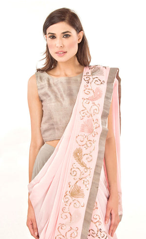 The muse here is wearing our rose pink ready to wear dhoti sari drape with trousers. It is a playful look to spice up your traditional game into something really trendy. This comprises of a silk chiffon dhoti sari drape intricately embroidered with hand by using silk threads, sequins and silver work along the fall and pallu of the sari which is further paired with a simple and elegant raw silk crop-top and slim crepe trousers.
