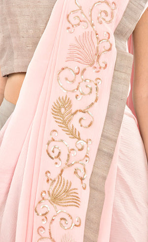 The muse here is wearing our rose pink ready to wear dhoti sari drape with trousers. It is a playful look to spice up your traditional game into something really trendy. This comprises of a silk chiffon dhoti sari drape intricately embroidered with hand by using silk threads, sequins and silver work along the fall and pallu of the sari which is further paired with a simple and elegant raw silk crop-top and slim crepe trousers.