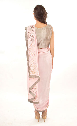 The muse here is wearing our rose pink ready to wear dhoti sari drape with trousers. It is a playful look to spice up your traditional game into something really trendy. This comprises of a silk chiffon dhoti sari drape intricately embroidered with hand by using silk threads, sequins and silver work along the fall and pallu of the sari which is further paired with a simple and elegant raw silk crop-top and slim crepe trousers.