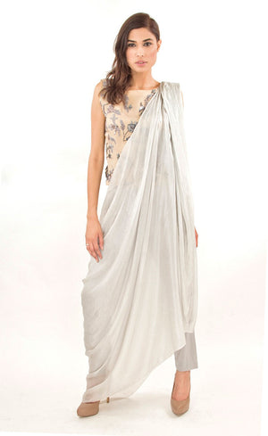 The muse here is wearing our silver grey ready to wear sari drape with trousers. It is a perfect look to spice up your traditional game to something really trendy. This comprises of a silk sari drape paired with a silk organza intricately embroidered crop top hand embroidered with silk threads, sequins, beads and silver grey work. The outfit is paired with slim crepe trousers.