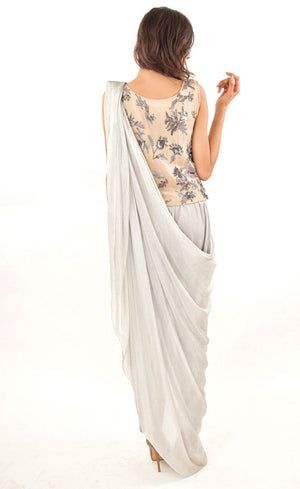 The muse here is wearing our silver grey ready to wear sari drape with trousers. It is a perfect look to spice up your traditional game to something really trendy. This comprises of a silk sari drape paired with a silk organza intricately embroidered crop top hand embroidered with silk threads, sequins, beads and silver grey work. The outfit is paired with slim crepe trousers. 