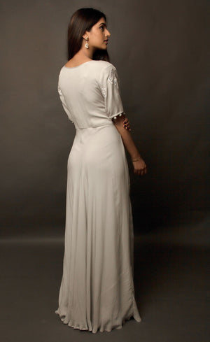 Steel grey flared gown, with beautiful sleeves achieved by handmade sequin buttons - a personal detail that only the wearer can experience, the gown is embroidered with signature thread-work further highlighted by sequins on the front yoke. This flowing gown set in a neutral palette entails a beautifully weightless flare, allowing you to express more freedom of movement.
