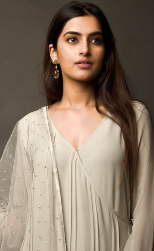 This angrakha in steel grey is highlighted with vertical pin-tucks all across the kurta. It is paired with a minimally sequin sprayed tulle fine net dupatta, that is further finished with a raw silk border. The look is completed with a stretch crepe churidaar / slim pants.