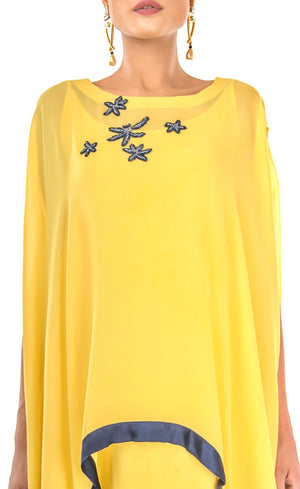 The muse here is wearing our sunflower yellow cape dress crafted in cupro georgette. Elegant and effortlessly trendy, this cape dress will keep you looking fabulous all day and night. This dress accompanies a slightly fitted inner silhouette, a fashion-forward cape embroidered with deep blue beads and sequins making it an elegant resort and holiday lounge style and a subtle back.
