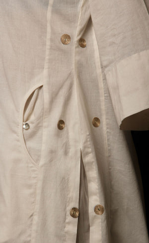 The muse is wearing a classic kurta set style, enhanced with added godet panels. This kurta is crafted in 100% cotton, is delicately embroidered with aari zari work paired with relaxed palazzos and accompanied by a 100% cotton dupatta embroidered with a coordinating zari border.