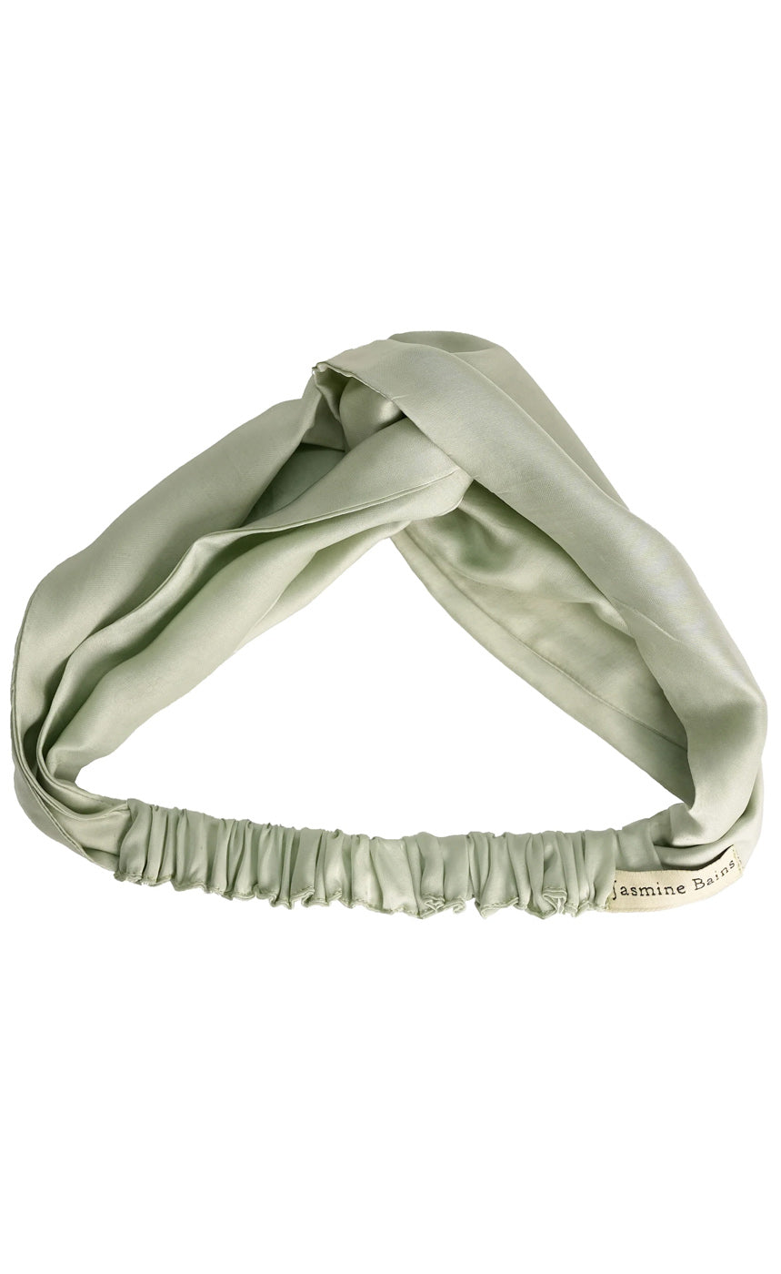 Green headband with a twisted design on a white background