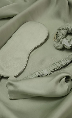 Light green fabric with a headband and scrunchie on a matching background