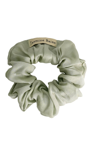 Light green scrunchie with a brand label on a white background