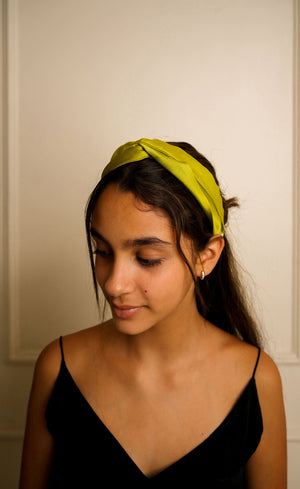 Model wearing green satin knotted headband, side profile, Jasmine Bains handcrafted accessory