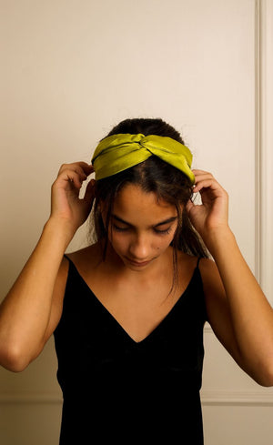 Silk hairband in olive green, hand-twisted knot detail, worn on model – Jasmine Bains slow fashion