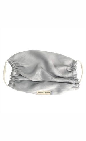Silver satin face mask with brand name on a white background