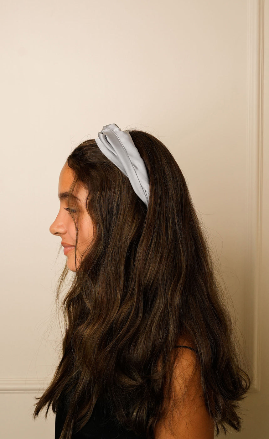 Woman wearing a light blue headband against a neutral background