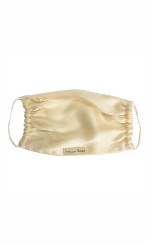 Gold satin face mask with a brand logo on a white background