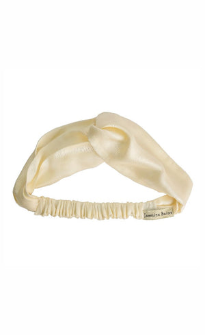 Cream-colored satin headband with a bow on a white background