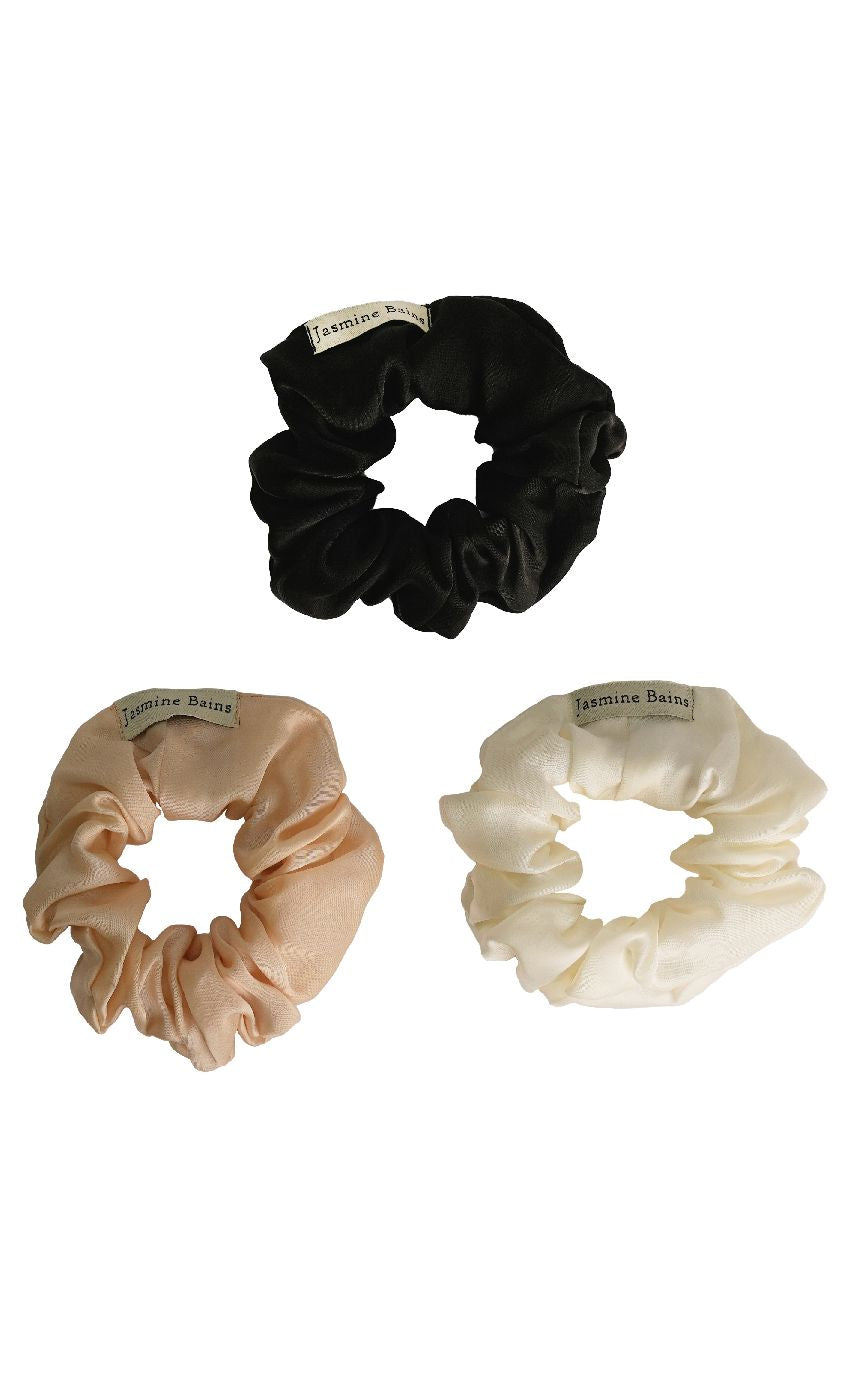 Three scrunchies in black, beige, and white on a white background