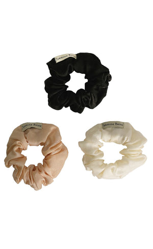Three scrunchies in black, beige, and white on a white background