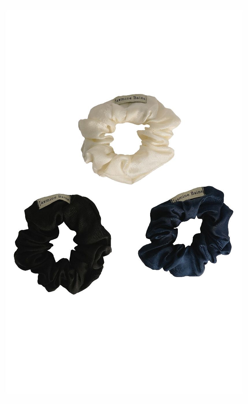 Three scrunchies in black, white, and navy on a white background