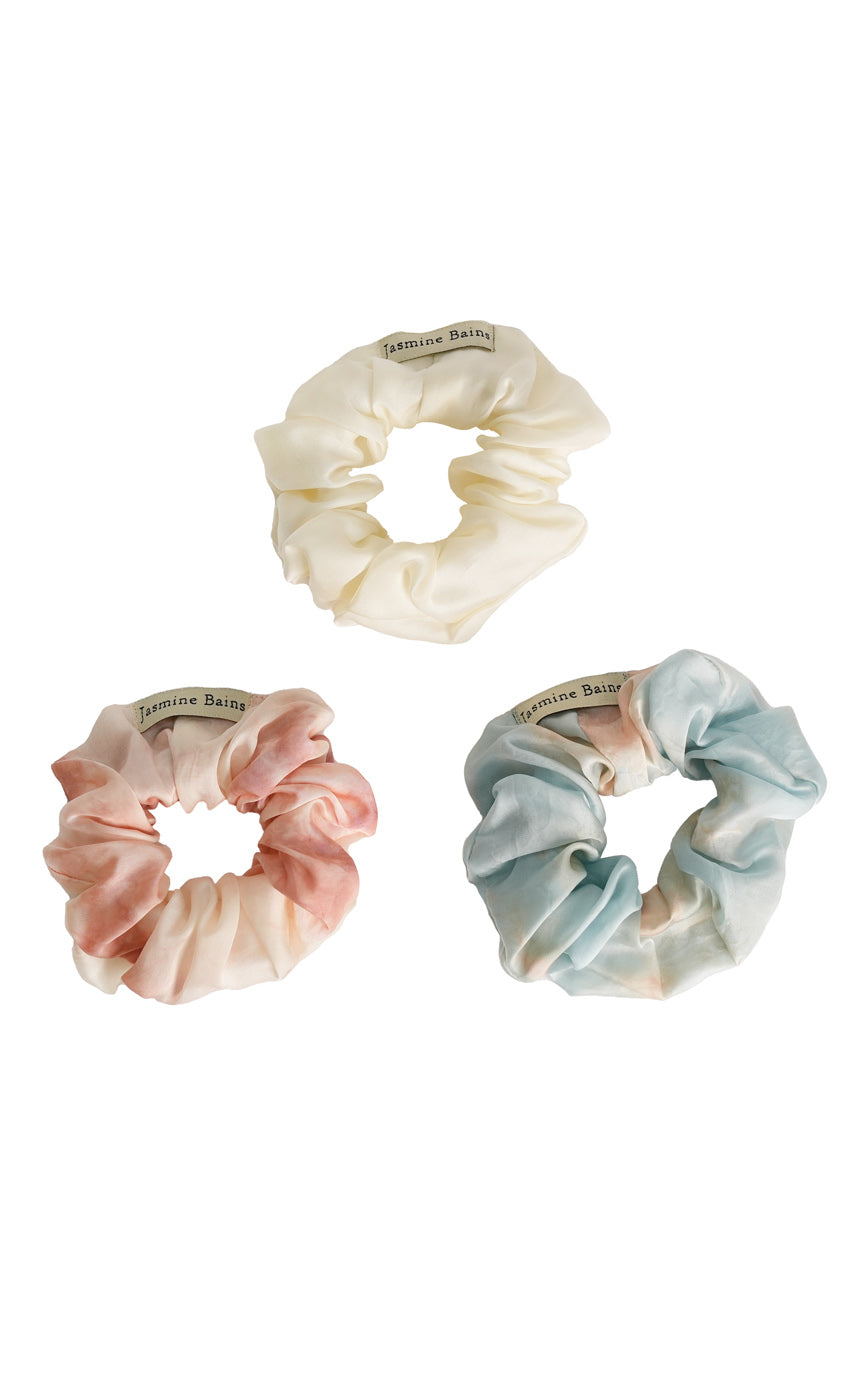Three scrunchies in different colors on a white background