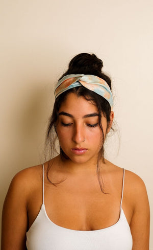 Woman wearing a patterned headband against a beige background