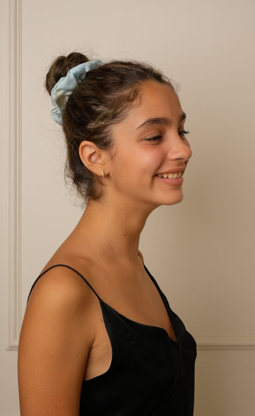 A model styled in a blue scrunchy. 