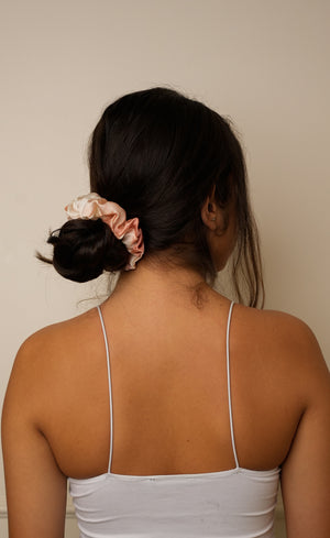 Person with a hair scrunchie on a plain background