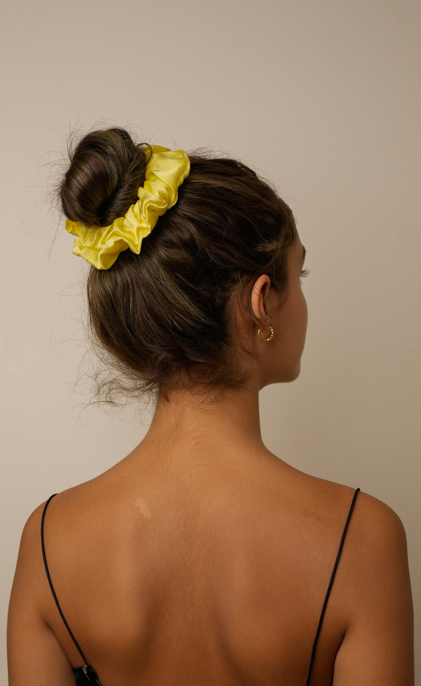 Side view of Lime Green satin scrunchie in high bun black top — Jasmine Bains no-crease hair accessory