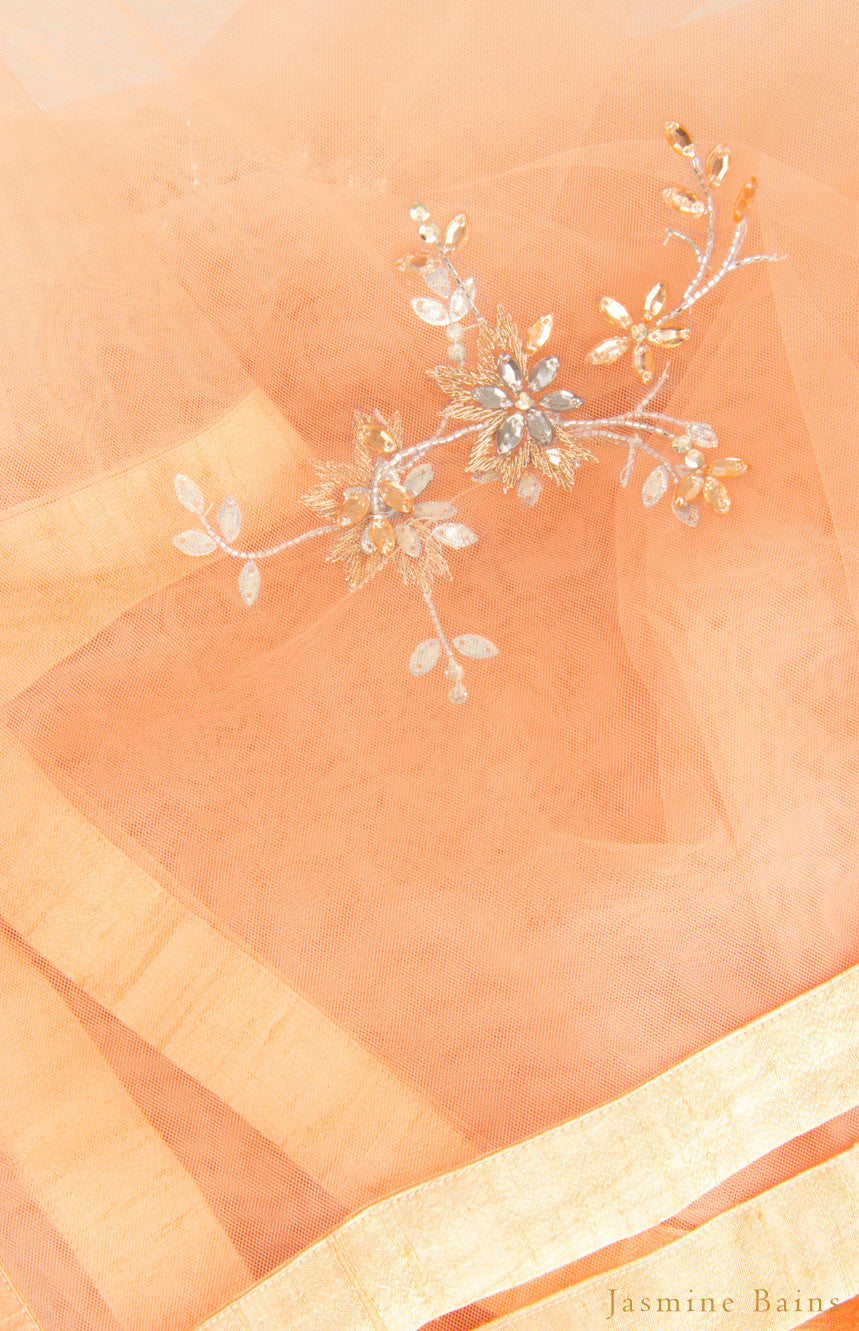 This is our beautiful tulle net dupatta with intricate hand-embroidered beaded motifs all over the body further finished with a coordinating raw silk border. This dupatta is effortlessly elegant with it's minimal work thus will add up to your look. 