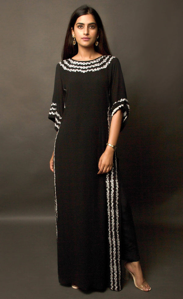 The muse here is wearing an alluring black kaftan. This is a cupro georgette kaftan intricately embroidered with our signature raised thread-work on the neckline, high slits and flared sleeves having a zipper at the back center. The look is completed when paired with cupro georgette slim trousers.