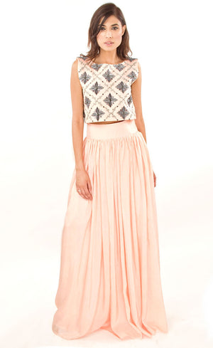The muse here is wearing our blush pink cropped top with skirt set. The dress comprises of a crop-top which has strong motifs embroidered with silk threads, beads, sequins and silver grey work, paired with a highly flared skirt providing you the perfect amount of flow which is further attached to a thick waistband. This skirt set is perfect as it highlights the waistline and makes the person wearing it look taller and perfects the height ratio. 