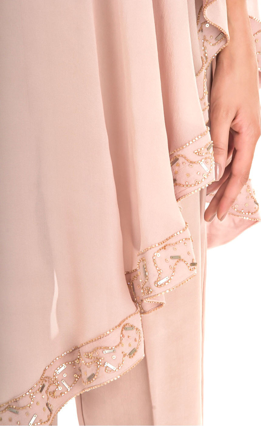 This is our naturally beautiful and effortlessly elegant hazelnut side cape trouser-set. Crafted asymmetrically in georgette this one shoulder cape is intricately embroidered with bead-work embroidery and sequins along flowy flared border of the cape which is further paired with cupro straight trousers with metal buttons finishing on the bottom cuff sides.