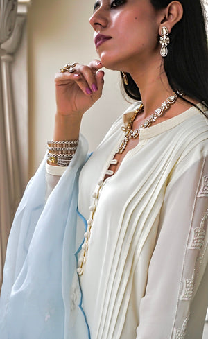 The high neckline has a anchor Kurta patti with handmade fabric loop-buttons. The sleeves are embellished along the length with signature beads and sequins handwork, with anchor cuffs.