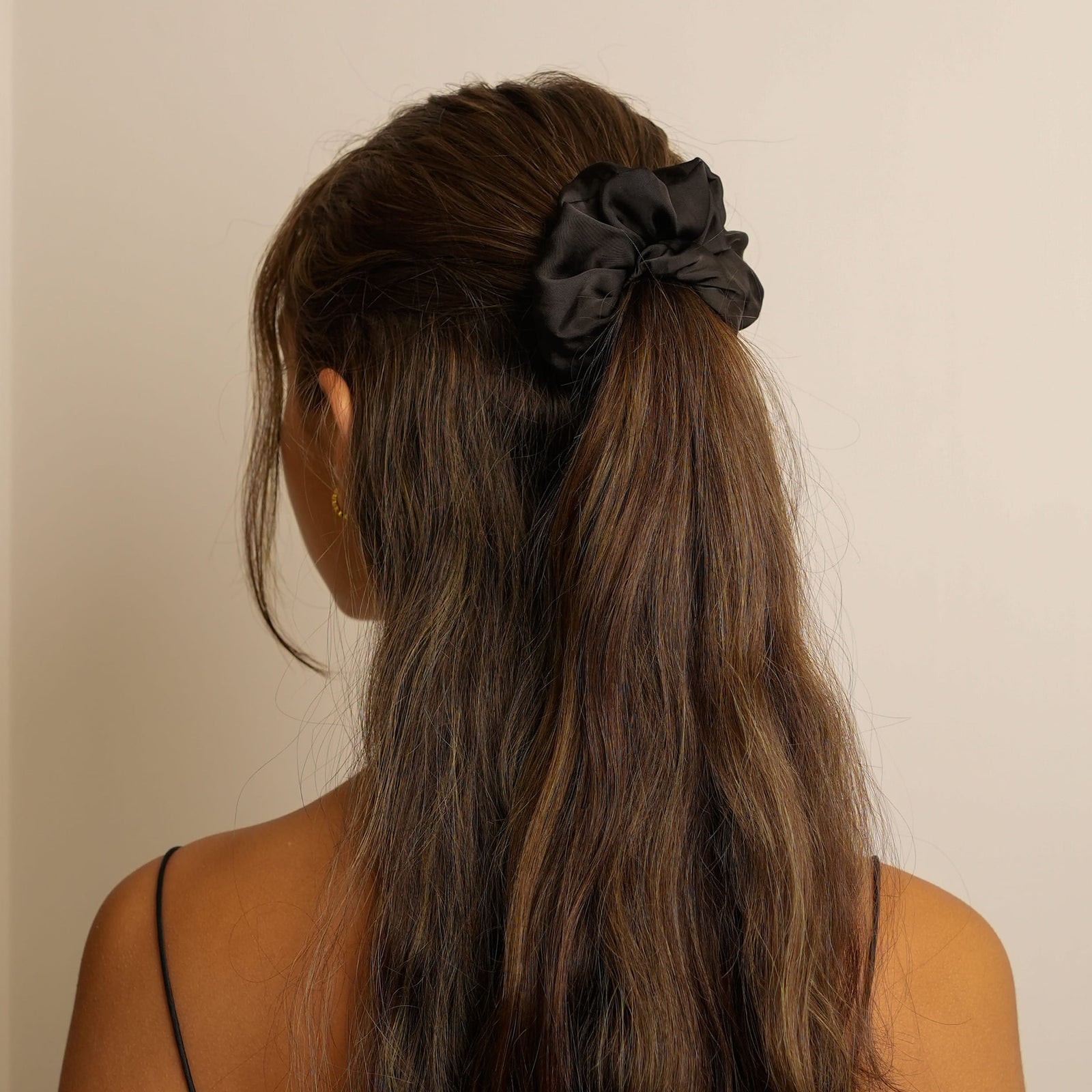Elegant black silk scrunchie for ruffled hairstyles.