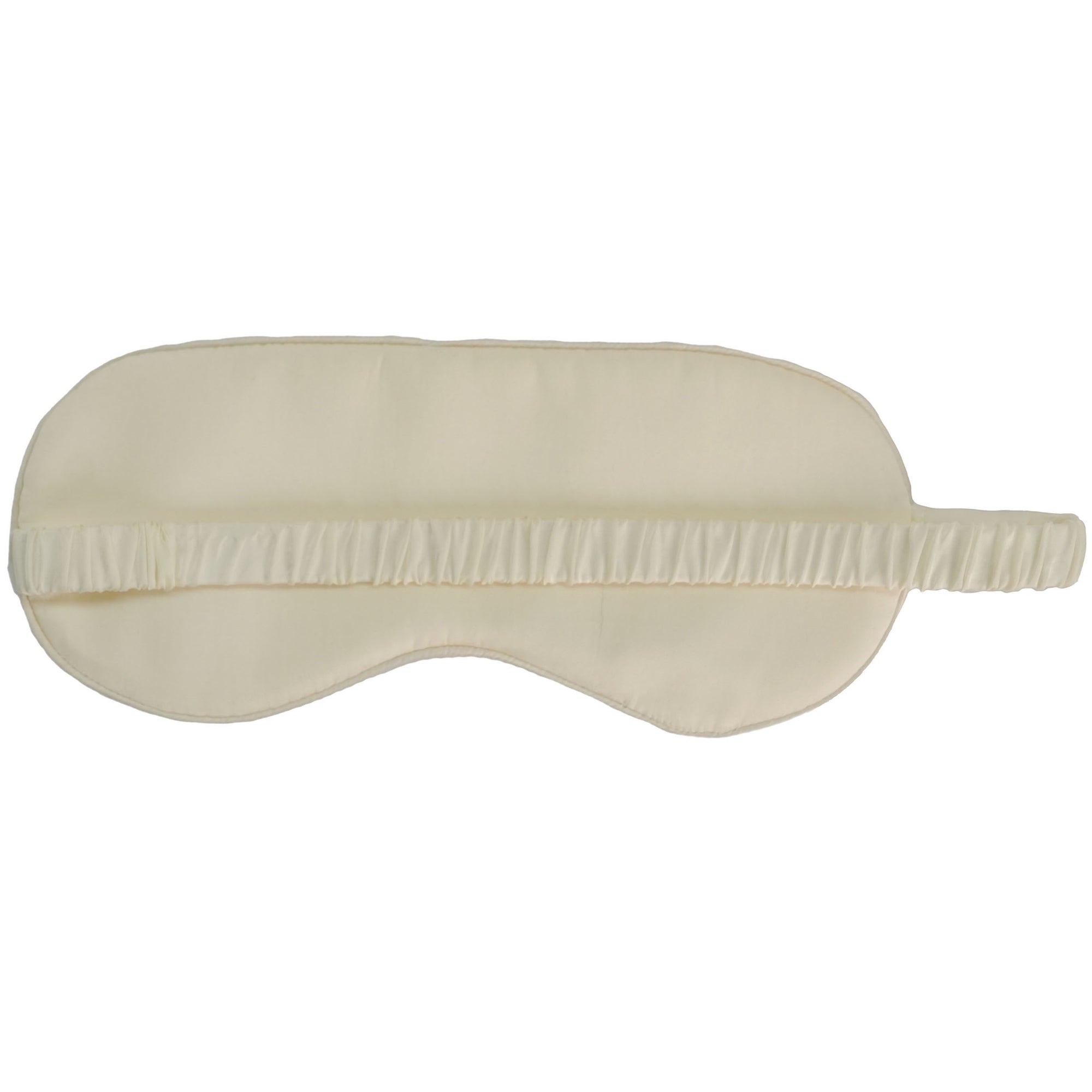 Mulberry silk sleep mask resting on a bedside table.
