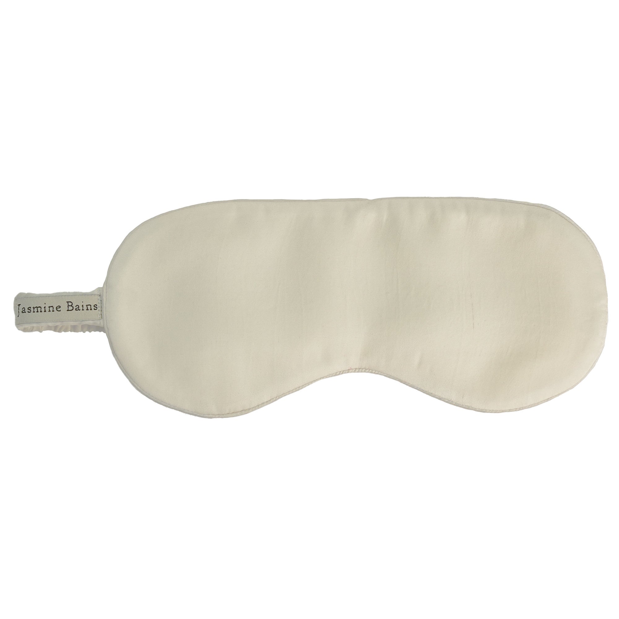 Elegant mulberry sleep mask displayed on a bed.
