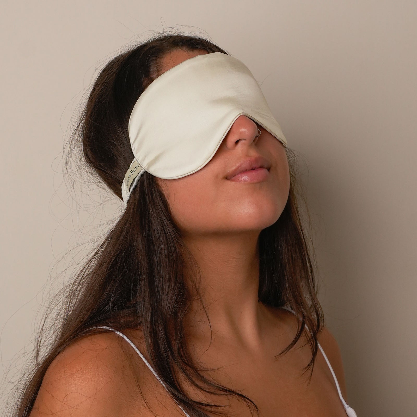 Soft mulberry silk eye mask for sleeping on a pillow.
